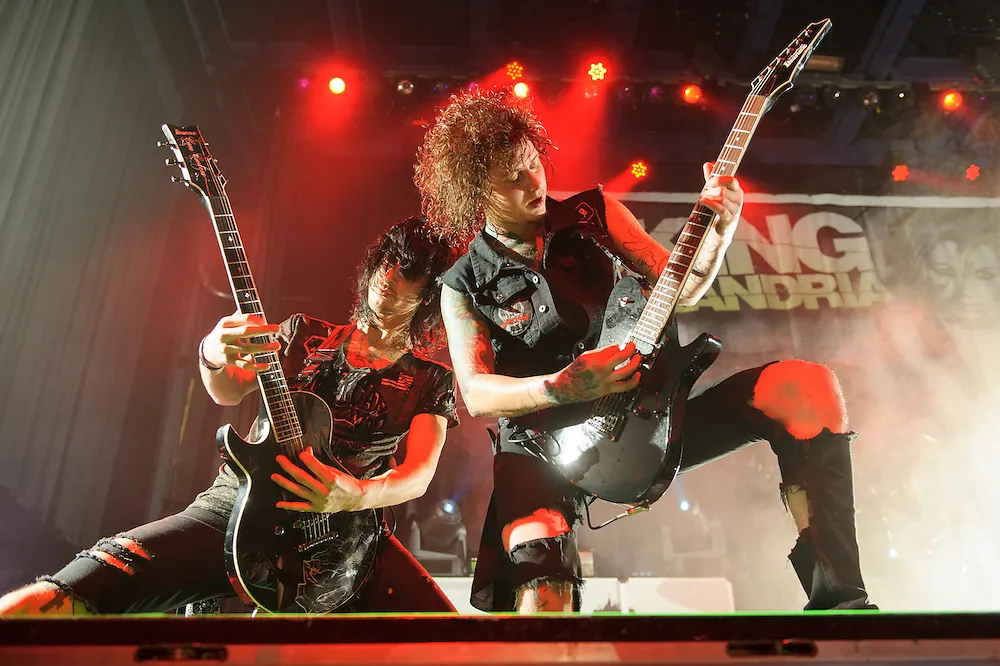 Asking Alexandria musicians performing under dramatic concert lights
